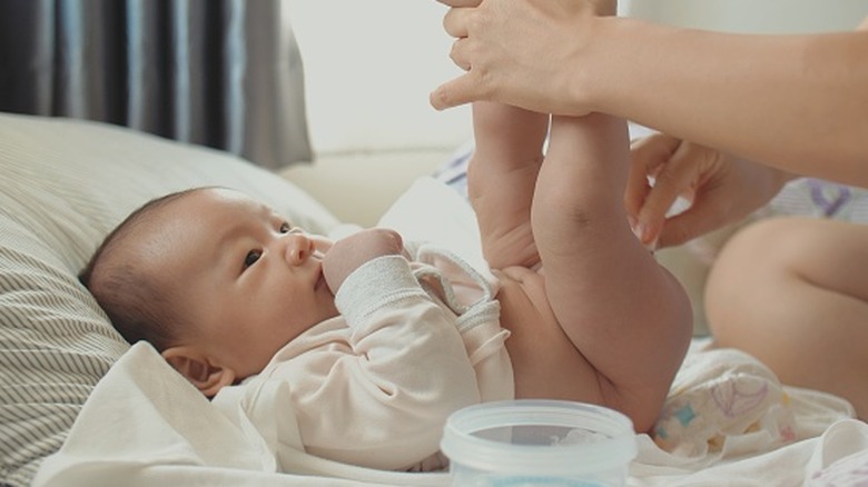 parent changing baby's diaper