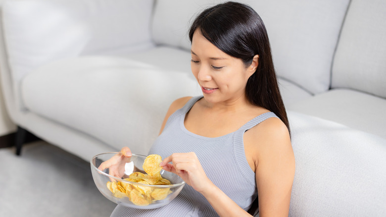 Pregnant woman eating chips