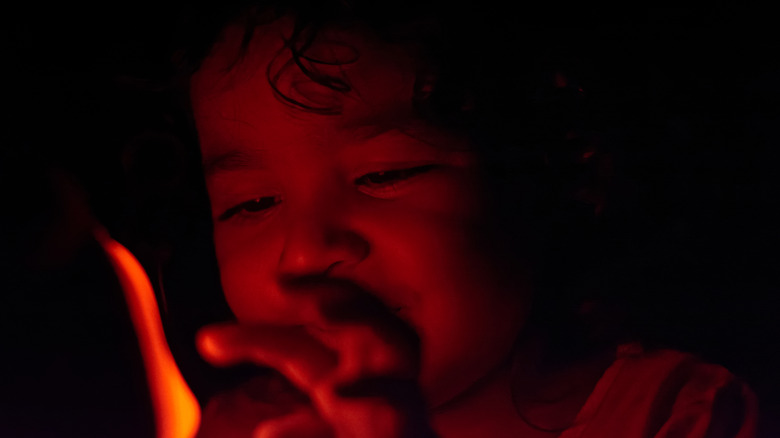 Young child touching red night light