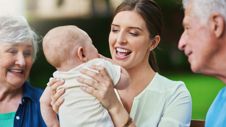 Multiple generations holding and playing with a baby