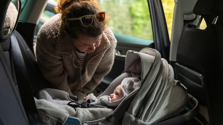 baby tucked into a rear-facing car seat