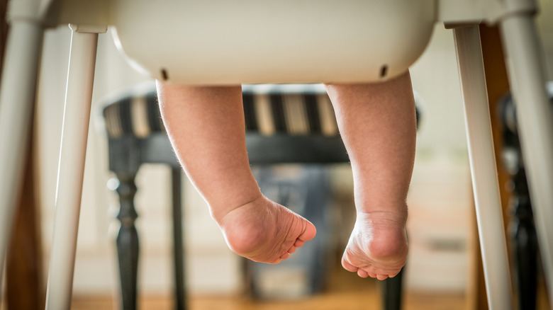 baby feet dangling from a high chair