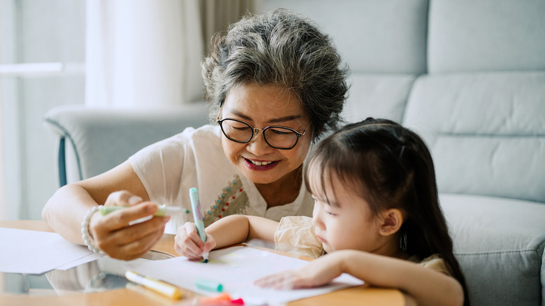 A grandmother enjoys coloring with her granddaughter