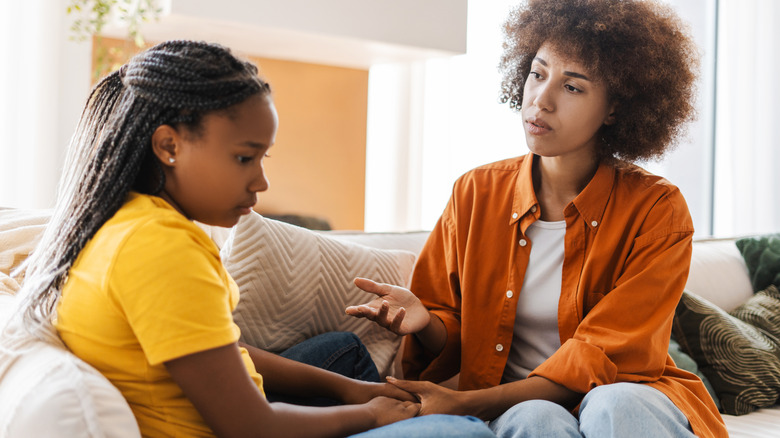 Mother talking to her upset daughter on the couch