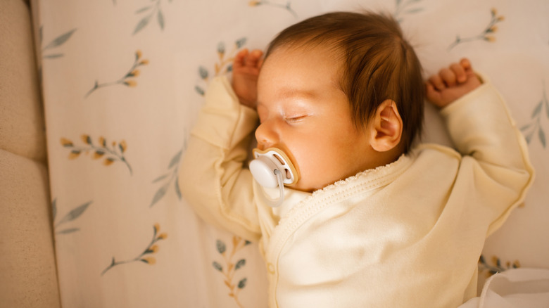 close up of pacifier and baby sleeping