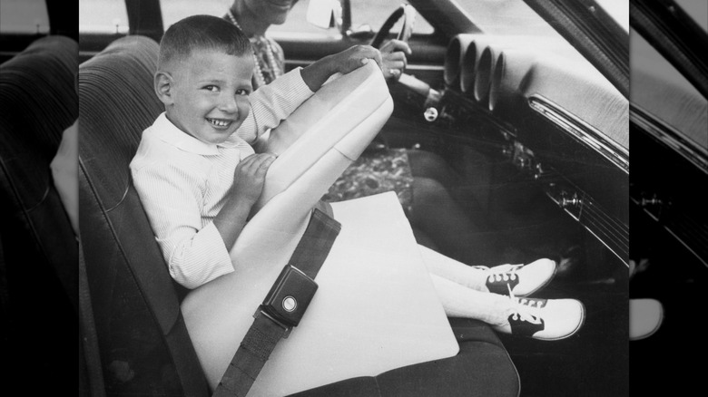 child smiling and sitting in a Tot-Guard car seat