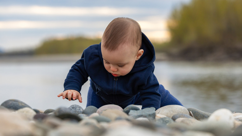 baby boy playing in the river